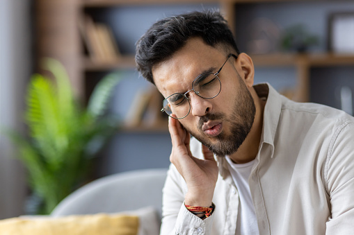 Man holding his ear and in pain due to sound sensitivity. 